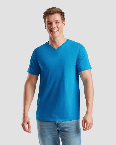 Man wearing a blue t-shirt and jeans on a light gray background